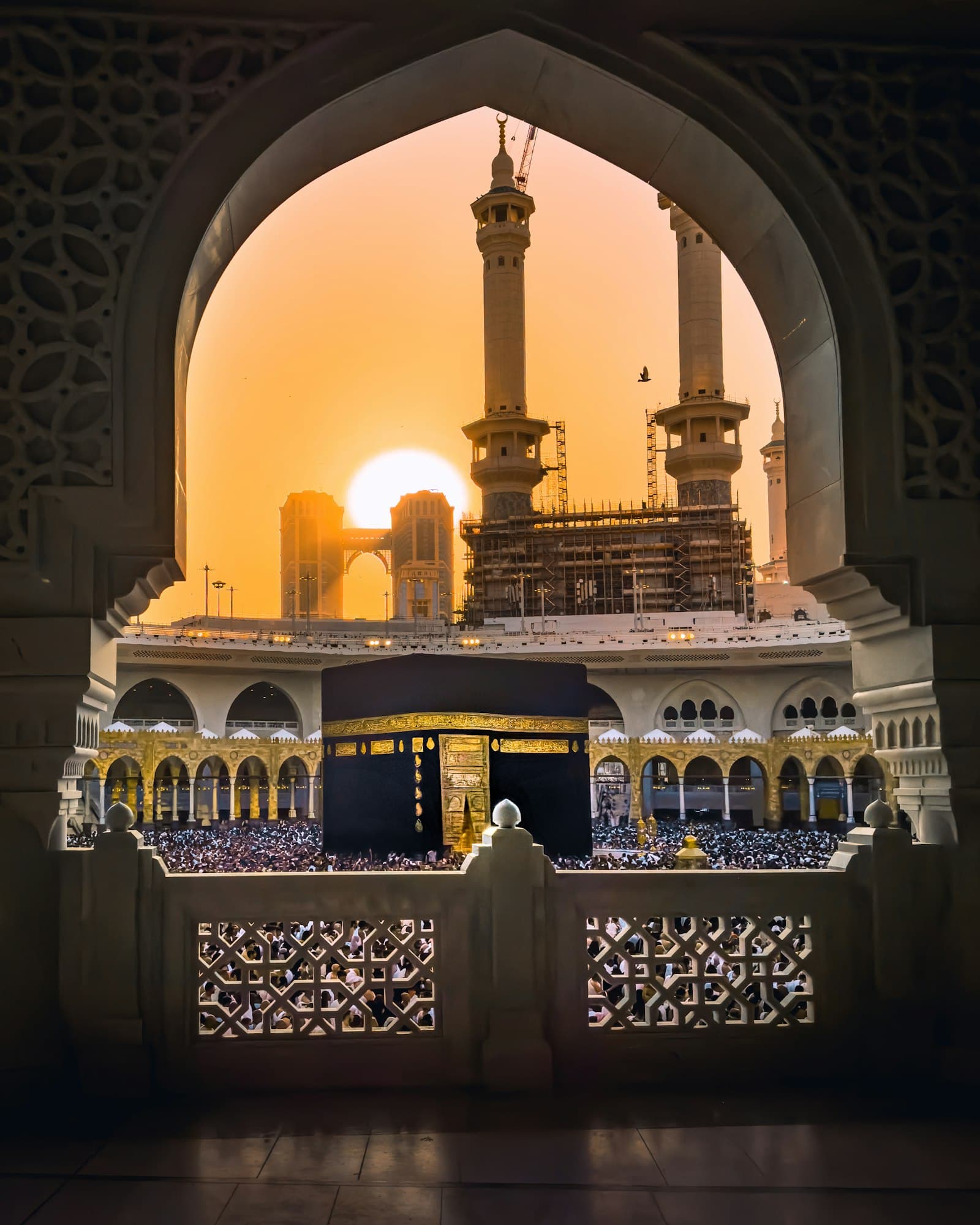 La Kaaba dans la Grande Mosquée de La Mecque, vue à travers une arche au coucher du soleil